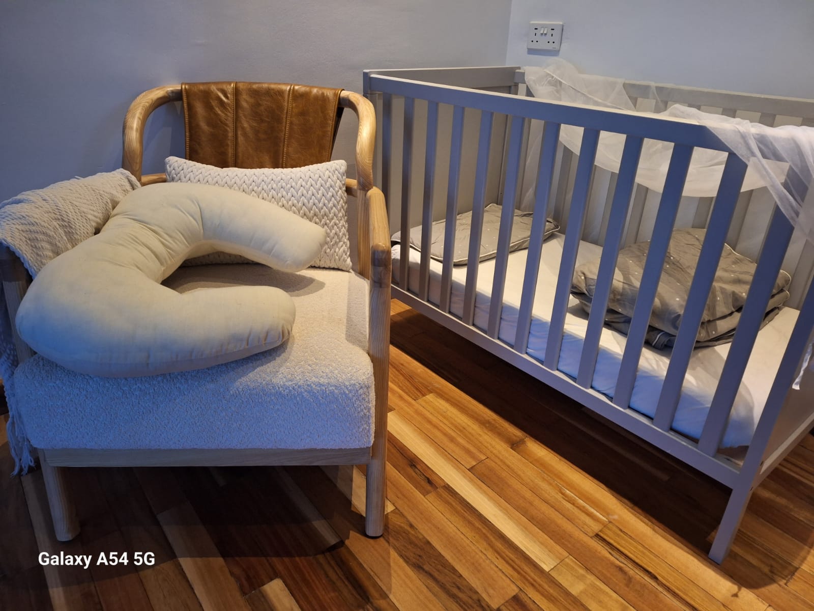 Newborn Baby nursery crib with a firm mattress cover and protector, blanket, mosquito net a comfortable chair when breastfeeding and nursing pillow